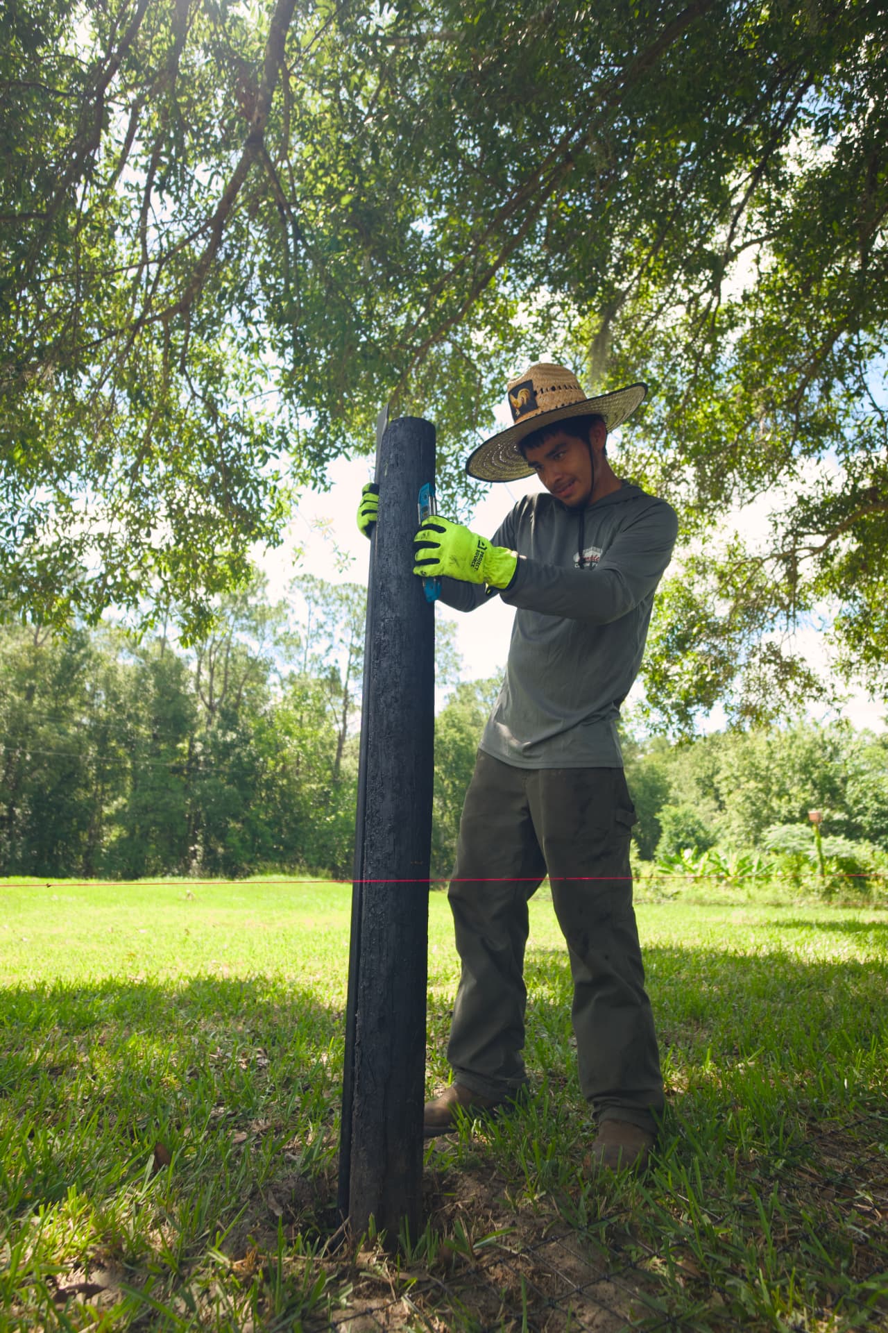Complete Custom Fence installer setting a fence post
